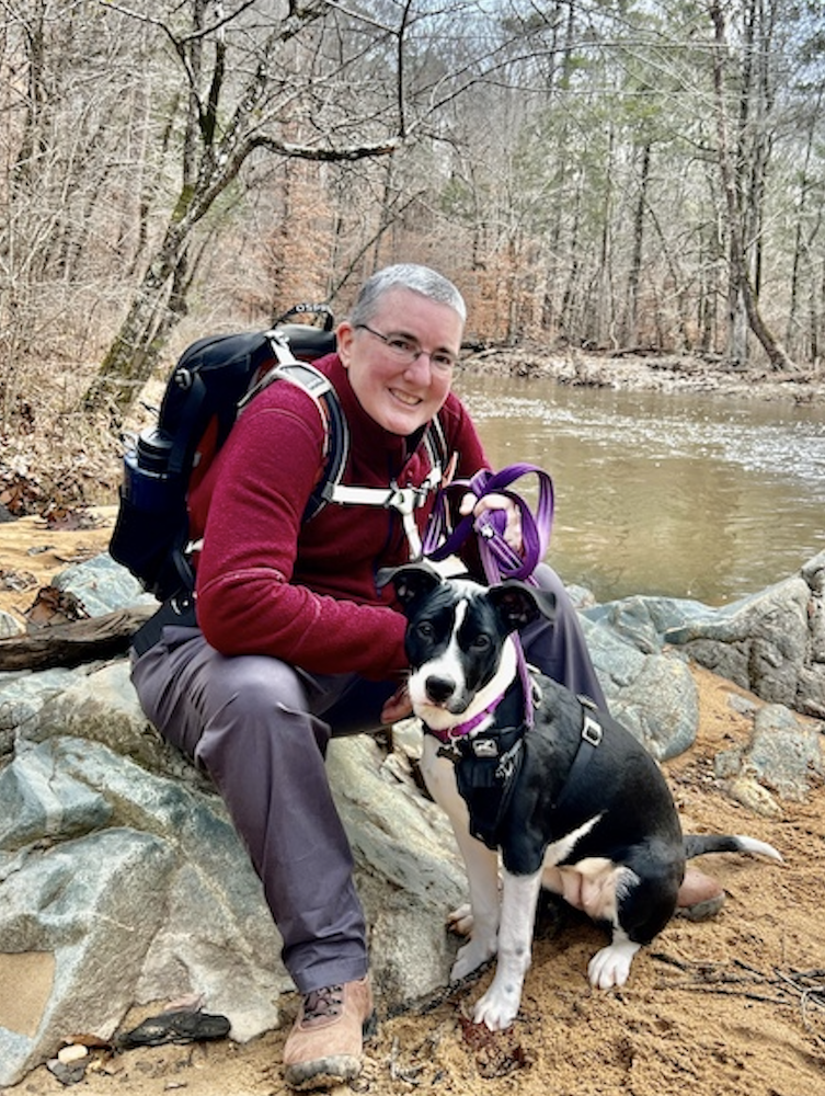 Terri Phoenix and Daisy the dog resting on a hike